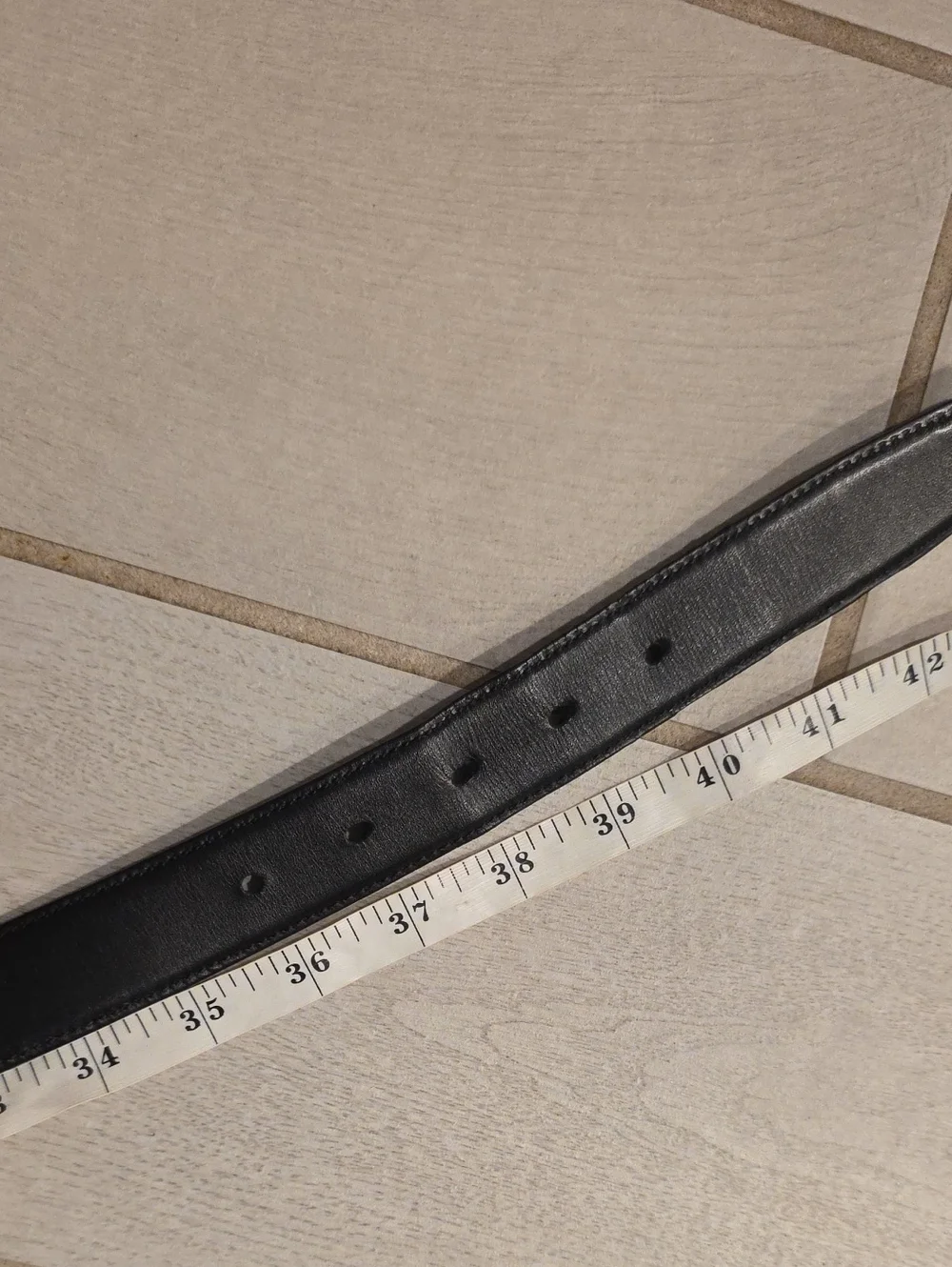 Black leather Coach belt. Reversible embossed Coach signature logo on one side.